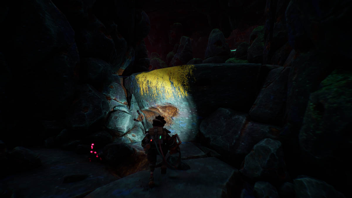 Zu sehen ist eine dunkle Höhle, von einer Taschenlampe angestrahlt wird eine gelbe Kante: Hier kann ich klettern!