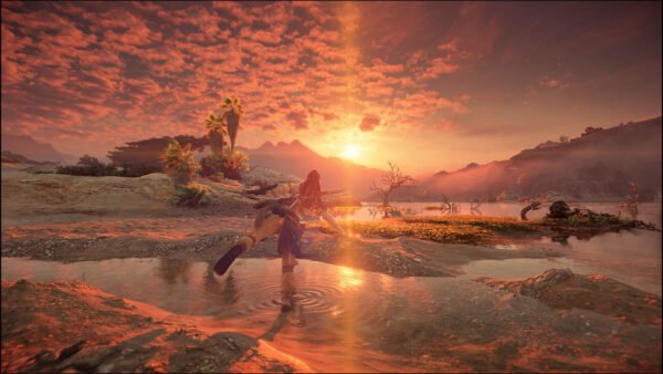 Auf dem Bild geht die Sonne über einem See unter. Am Strand steht eine junge Frau, balancierend auf einem Bein.